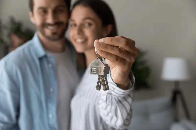 Happy couple holding keys to their dream home